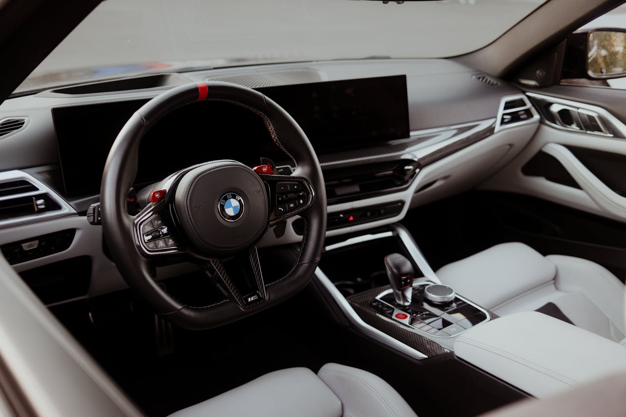Sleek and modern luxury car interior focusing on the steering wheel and central console.
